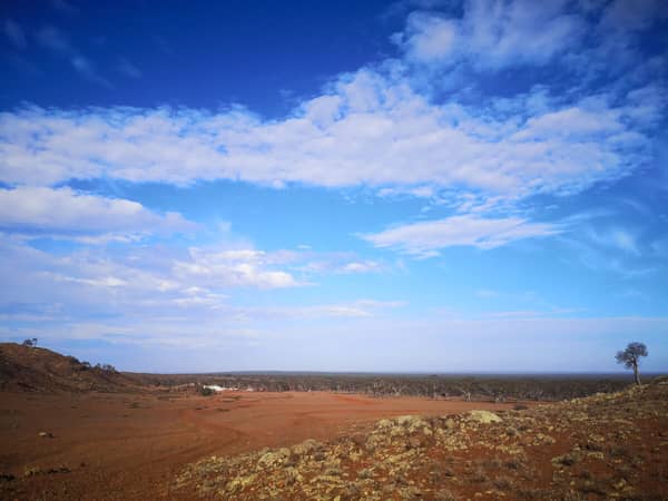 Dry, barren plain with blue sky.