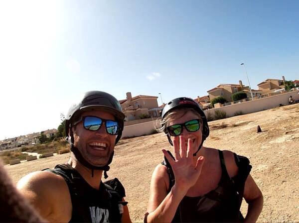Man and woman still wearing helmets after paragliding in Alicante.