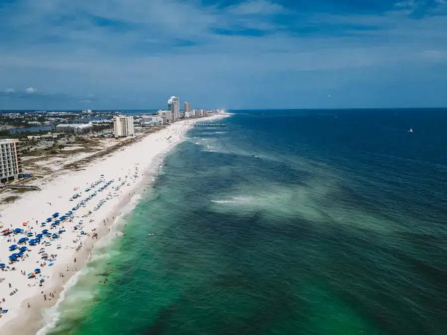 Aerial view of Orange Beach, the long sandy beach and turquoise ocean.