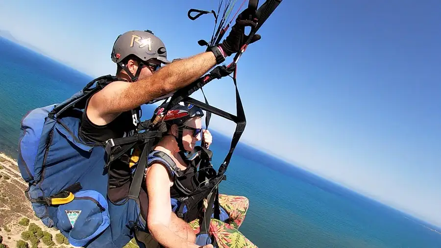 Pilot and woman tandem paragliding in Alicante over the sea.