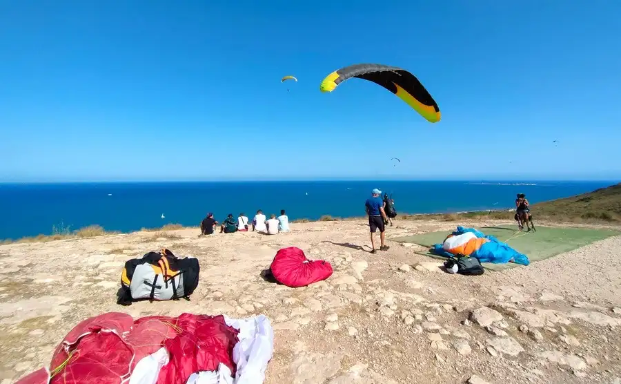 Alicante paragliding launch site atop Santa Pola cliffs with paragliders and canopies.
