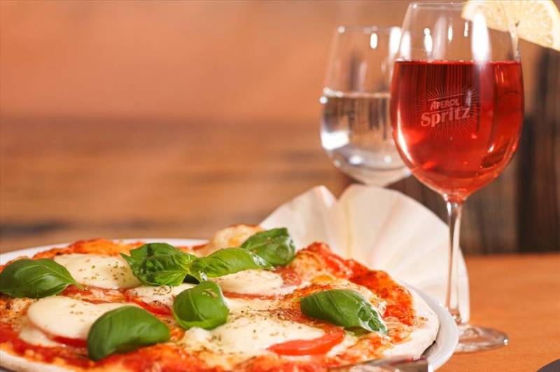 Slice of pizza with an Aperol Spritz in Bologna, Italy.