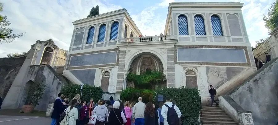 Farnese Aviaries is a historic grey building with a staircase either side on Palatine Hill.