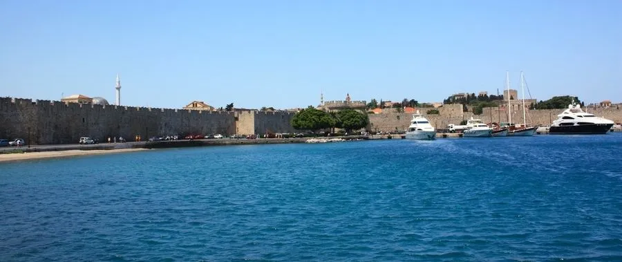 View over turquoise sea to the fortified walls of Rhodes Island.