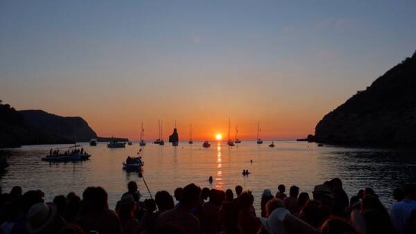 Sunset over a bay with sailing boats.
