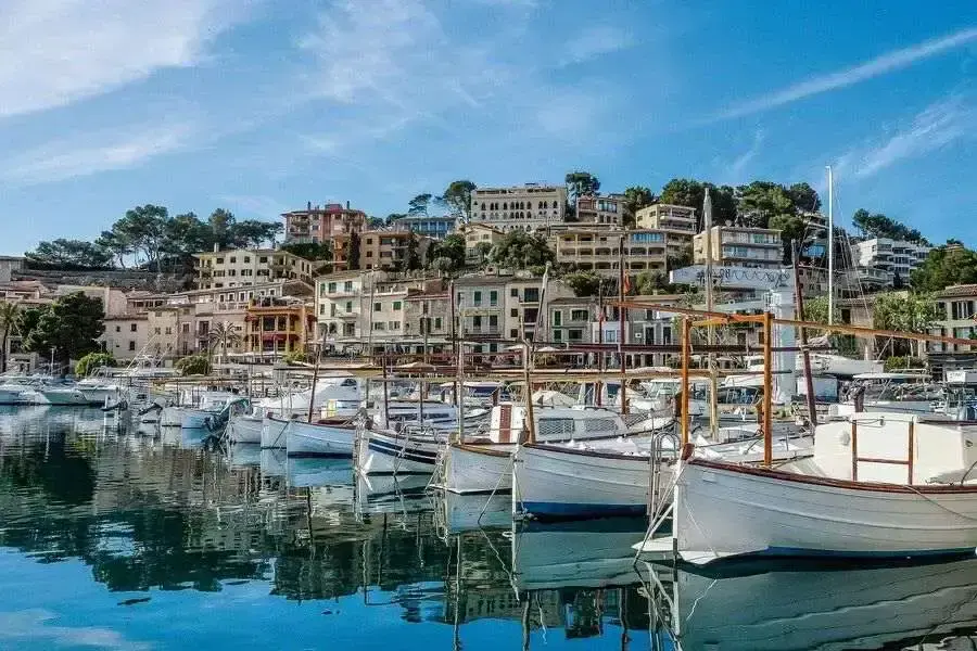 Boats moored in leisure harbour with buildings behind on a hill.