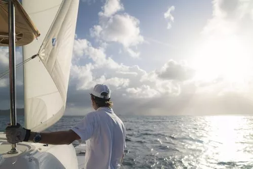 Yachtman on sailing boat at sea.