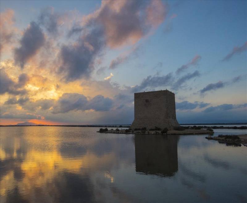 Torre Tamarit on Santa Pola salt lakes at sunset in Spain.