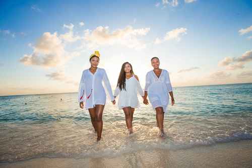 3 women walking in the sea on a women-only tour.