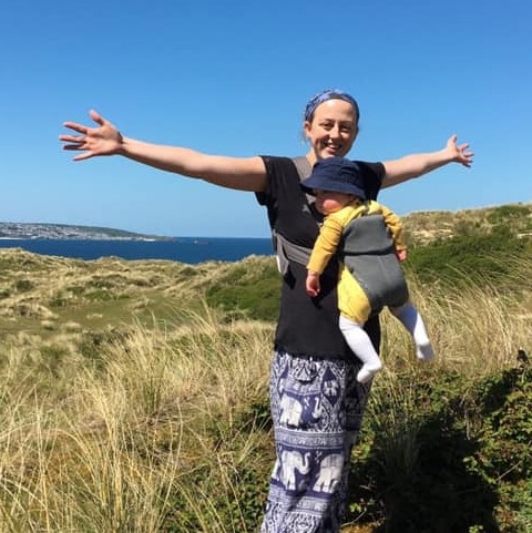 Sylvie Simpson in the Cornish countryside holding her baby daughter.
