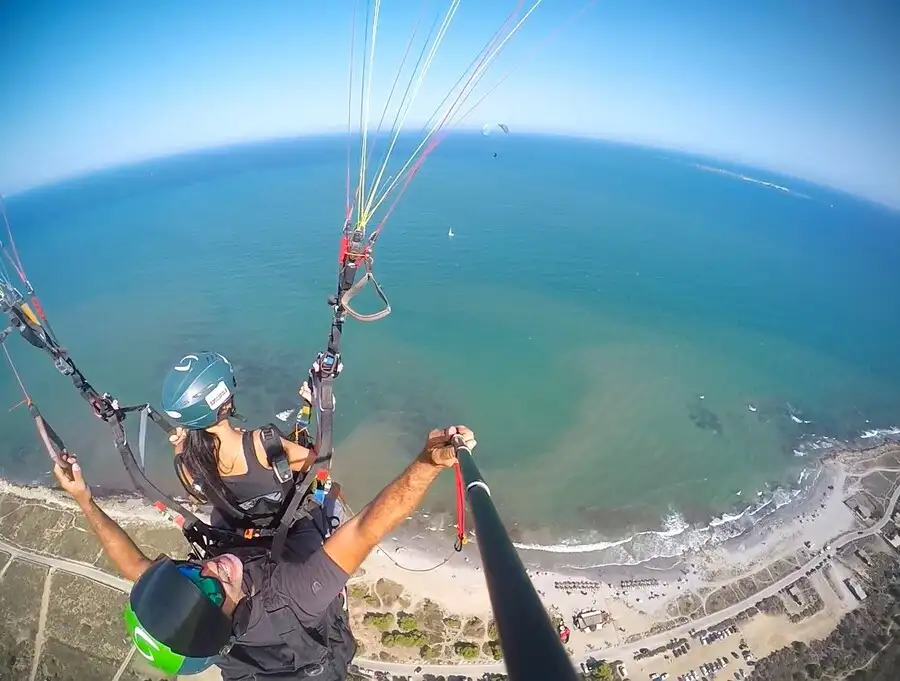 Aerial view taken with selfie stick of tandem paragliding in Alicante over the coast.