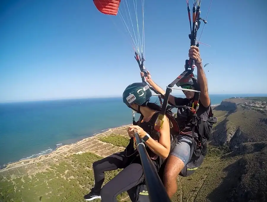 Man and women on a tandem paraglider above Alicante coastline.