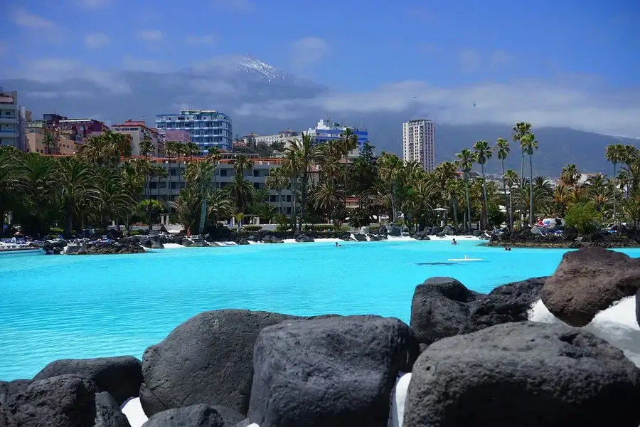 Huge tropical swimming pool 'lake' with snow-capped mount Teide in the distance.