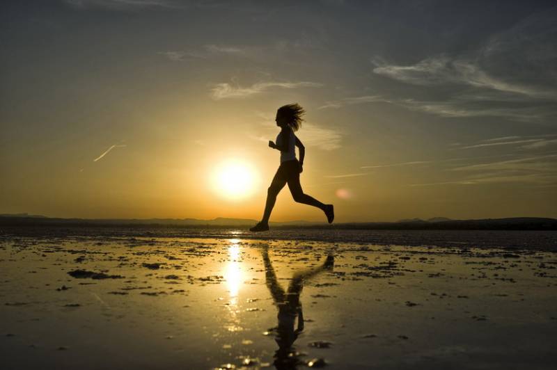 Woman jogging across Torrevieja sands at sunrise in Costa Blanca.