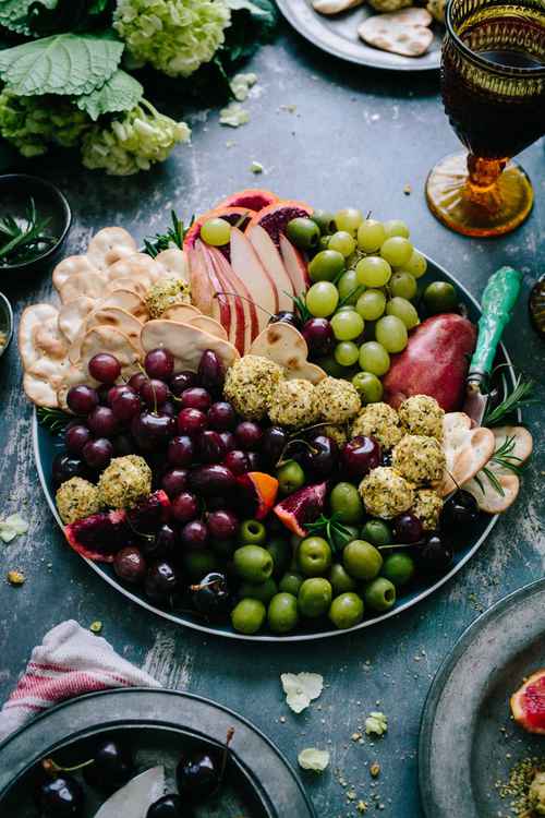 Tuscany platter with grapes, olives, cheese and wine.