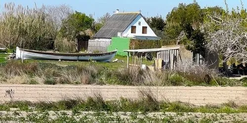 Canoa enfrente una barraca valenciana en la Albufera de Valencia.