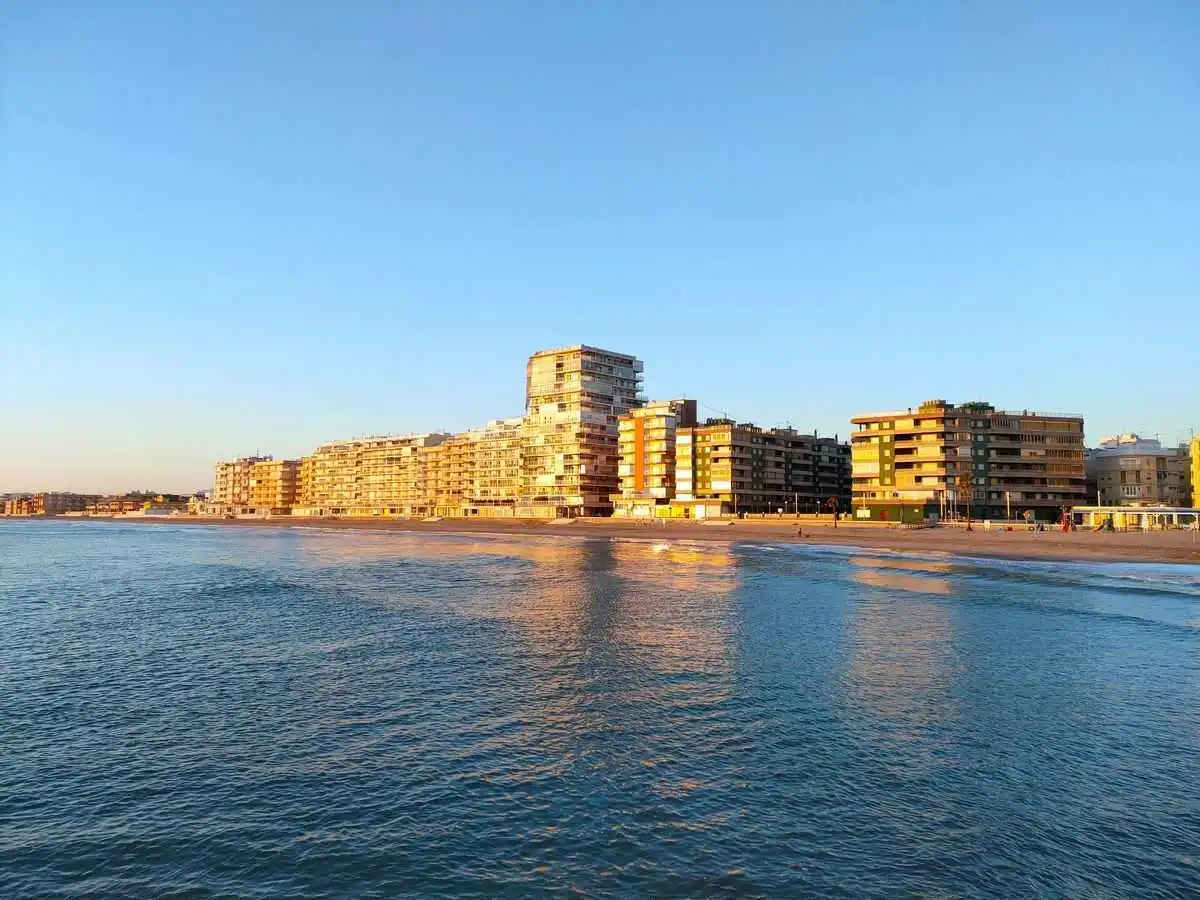 Mar Mediterranea con la playa de El Perelló al fondo bordeado por edificios.