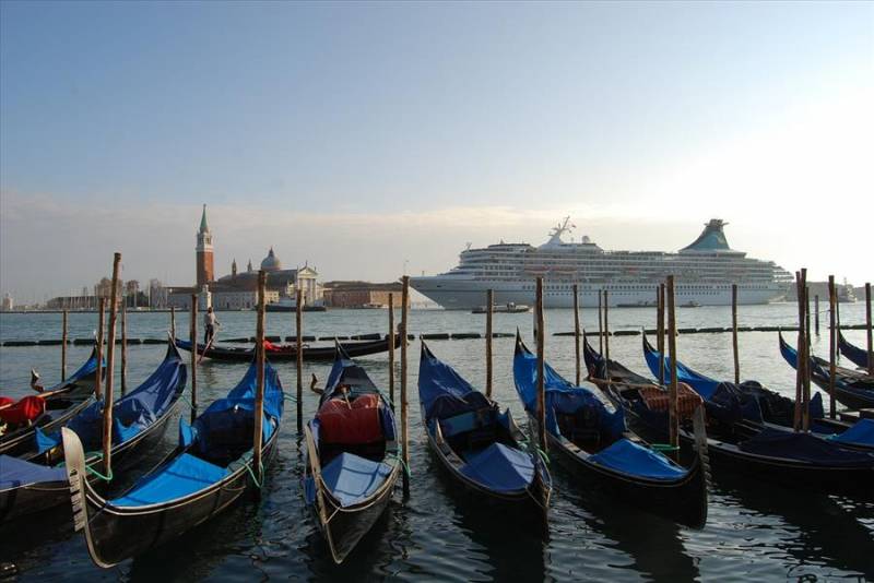 Gondolas in Venice with a cruise liner in St Mark's bay.