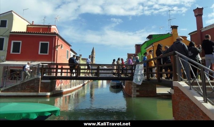 Tourists taking photos on Tre Ponti bridge in Burano Island