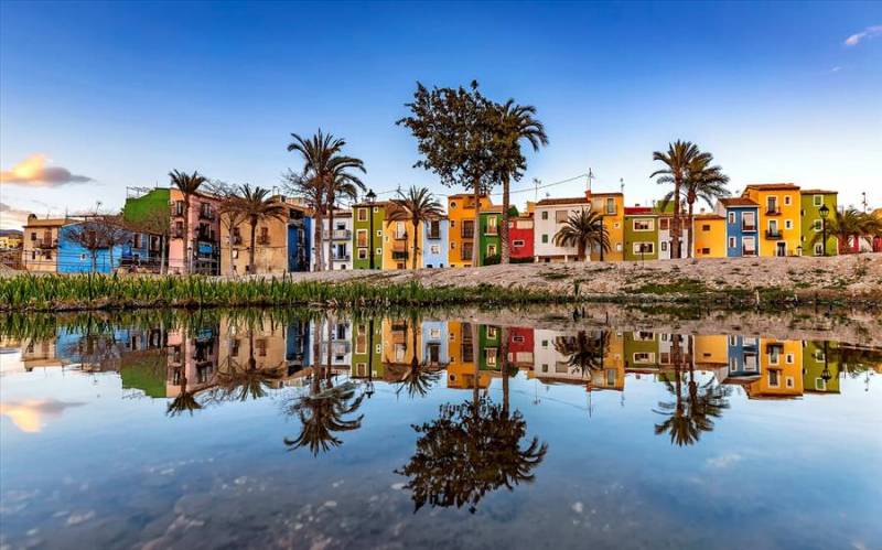 Typical colourful fishermen's houses in Villajoyosa reflecting in Mediterranean Sea, Spain.