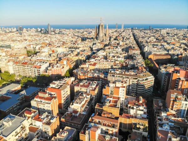 Panoramica aerial sobre los edificios de Barcelona hasta el mar.