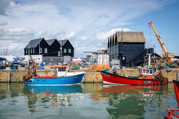 Traditional fishing boats & beach huts in Whitstable is a great day out from London